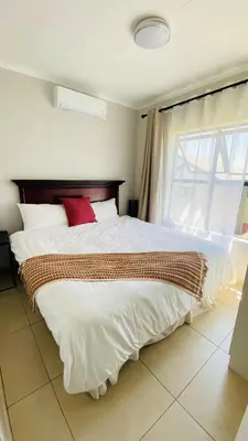 a bedroom with a large white bed with red pillows at Irenes home of nature in Nelspruit
