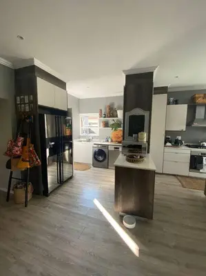 a large room with a kitchen with white cabinets at Lovely Family Home in Pecanwood Golf Estate in Kosmos
