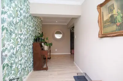 a hallway with a painting on the wall and a mirror at Lovely Family Home in Pecanwood Golf Estate in Kosmos