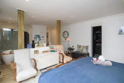 a bedroom with a bed and a bathroom with a tub at Lovely Family Home in Pecanwood Golf Estate in Kosmos