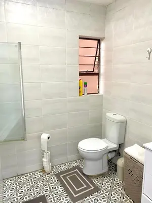 a bathroom with a toilet and a tile floor at Entire Apartment in Eldoraigne, Centurion in Eldoraigne