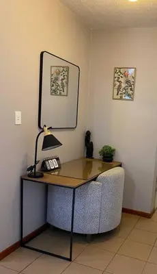 a desk with a lamp and a chair in a room at LA Montranquilo-Home of comfort in Pretoria