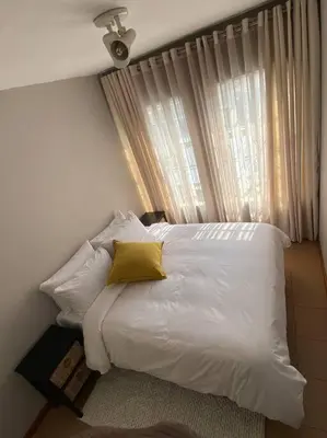 a bedroom with a white bed with a yellow pillow at LA Montranquilo-Home of comfort in Pretoria