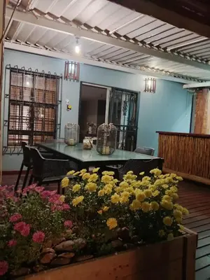 a dining room with a table and some flowers at LA Montranquilo-Home of comfort in Pretoria