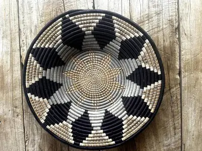 a woven basket with a star on a wooden wall at Bateleur Kruger Lodge in Marloth Park