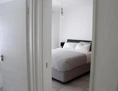 a bedroom with a bed with white sheets and pillows at Time Oon Travel & Tour The Blyde in Pretoria