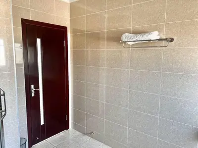a bathroom with a brown door and a tile wall at Euoren Living in Midrand