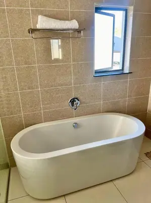 a white bath tub in a bathroom with a window at Euoren Living in Midrand
