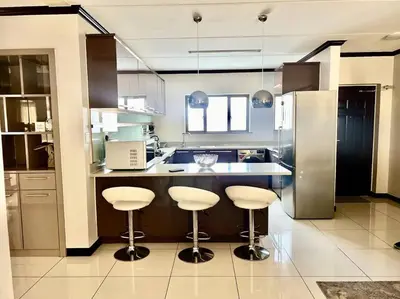 a kitchen with two bar stools and a counter top at Euoren Living in Midrand