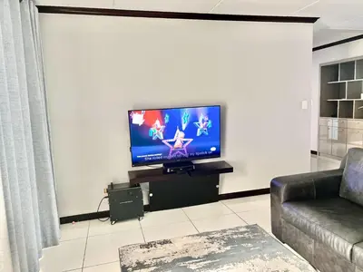a living room with a flat screen tv on a wall at Euoren Living in Midrand