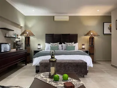 a large bedroom with a large bed and a table at Mountain Dew Guest House in Noordkaap