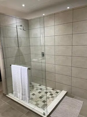 a bathroom with a shower with a glass door at Mountain Dew Guest House in Noordkaap