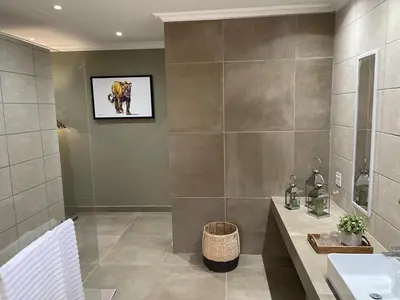 a bathroom with a sink and a picture on the wall at Mountain Dew Guest House in Noordkaap