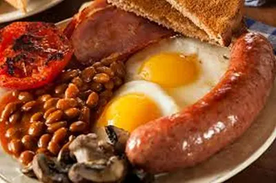 a plate of breakfast food with eggs sausage beans and toast at Mountain Dew Guest House in Noordkaap