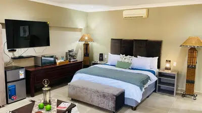 a bedroom with a bed and a flat screen tv at Mountain Dew Guest House in Noordkaap