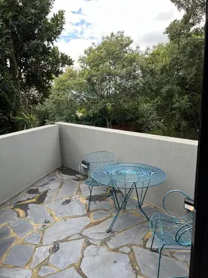 a patio with a table and chairs on a stone patio at Apartments on Herbert Baker in Pretoria