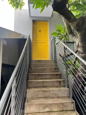 a yellow door on a building with stairs at Apartments on Herbert Baker in Pretoria