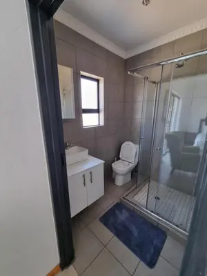 a bathroom with a shower and a toilet and a sink at Kanyamazane Guesthouse 1214 in eNyamazaneni