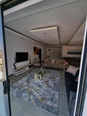 a living room with a large rug on the floor at Kanyamazane Guesthouse 1214 in eNyamazaneni