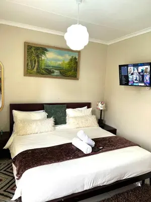a bedroom with a large bed with two towels on it at 17 Byvanger Luxury Home Deluxe King Suite Room 3 in Centurion