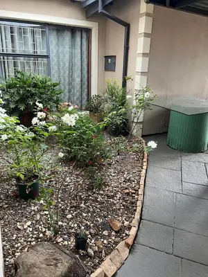 a garden with flowers and plants in front of a building at 17 Byvanger Luxury Home Deluxe King Suite Room 3 in Centurion