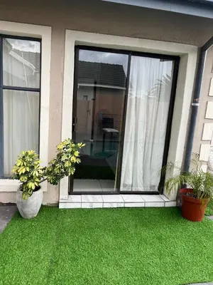a house with two potted plants on the grass at 17 Byvanger Luxury Home Deluxe King Suite Room 3 in Centurion