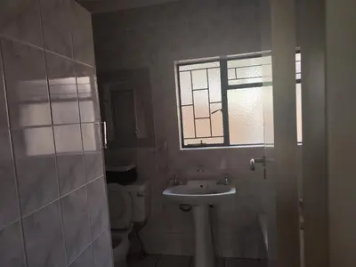 a bathroom with a sink and a toilet and a window at Escape in Pretoria