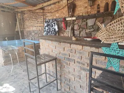 a brick wall with two chairs and a table at Escape in Pretoria