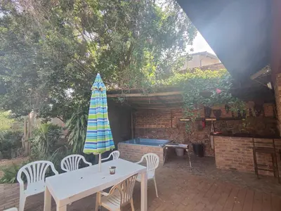 a patio with a table and chairs and an umbrella at Escape in Pretoria