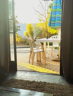 an open door to a patio with a table and an umbrella at Escape in Pretoria