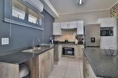 a large kitchen with a sink and a refrigerator at Lowveld Vivid Haven in Boschrand