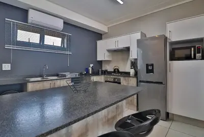 a kitchen with a refrigerator and a counter top at Lowveld Vivid Haven in Boschrand