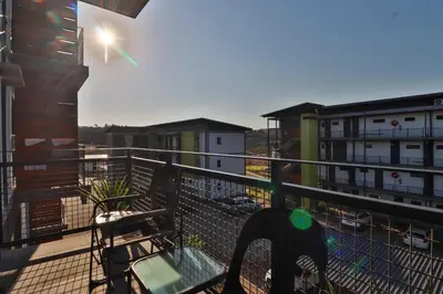a balcony with a bench and some buildings at Lowveld Vivid Haven in Boschrand