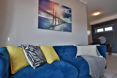 a blue couch with pillows on it in a living room at Lowveld Vivid Haven in Boschrand