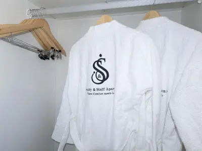 a white sweatshirt with a dollar sign on it hanging on a rack at Anna Suite - Serenity & Stuff Luxury Apartments in Midrand