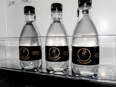 four bottles of water sitting on a shelf in a refrigerator at Anna Suite - Serenity & Stuff Luxury Apartments in Midrand