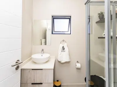 a bathroom with a sink and a shower at Anna Suite - Serenity & Stuff Luxury Apartments in Midrand