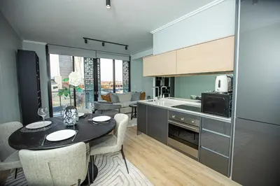a kitchen and living room with a table and chairs at Ellipse Executive Haven in Midrand