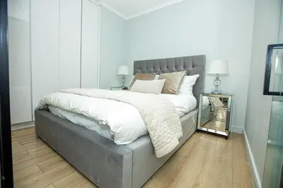 a bedroom with a large bed with a gray headboard at Ellipse Executive Haven in Midrand