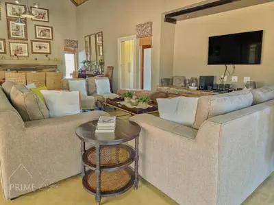 a living room with two couches and a table at Rhino Lodge at Zebula in Mabula