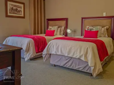 two beds in a hotel room with pink pillows at Rhino Lodge at Zebula in Mabula