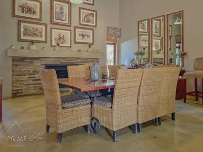 a dining room with a table and wicker chairs at Rhino Lodge at Zebula in Mabula