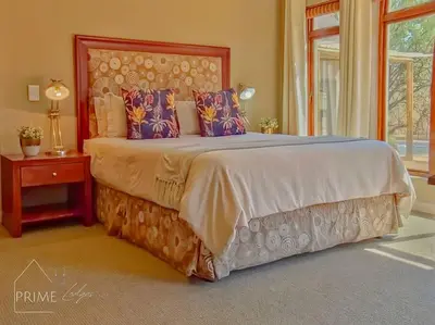 a bedroom with a large bed with a large headboard at Rhino Lodge at Zebula in Mabula