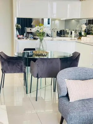 a glass table with chairs and a vase of flowers on it at Apartment Ellipse Waterfall in Midrand