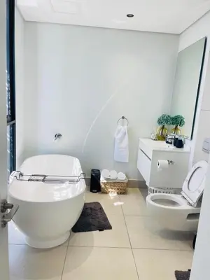 a white bathroom with a toilet and a sink at Apartment Ellipse Waterfall in Midrand