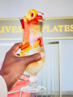 a hand holding a glass with a drink at Apartment Ellipse Waterfall in Midrand