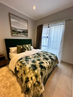 a bedroom with a large bed and a window at Luxury Studio Apartment next to Brooklyn Mall in Pretoria