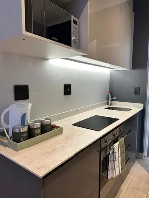 a kitchen with a counter with a sink and a stove at Luxury Studio Apartment next to Brooklyn Mall in Pretoria