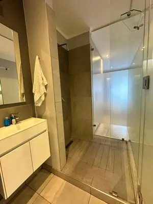 a bathroom with a shower with a glass door at Luxury Studio Apartment next to Brooklyn Mall in Pretoria
