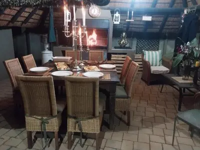 a dining room with a table with chairs and a chandelier at The Lion Room at Frederick's Place in Pretoria